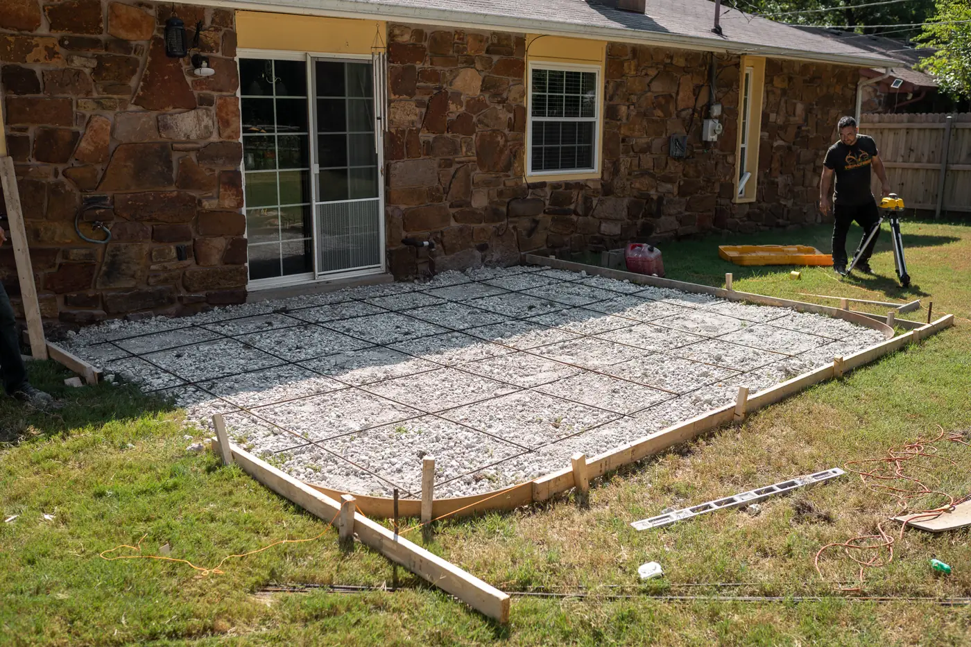 Backyard patio prepped with gravel base and rebar before concrete pour