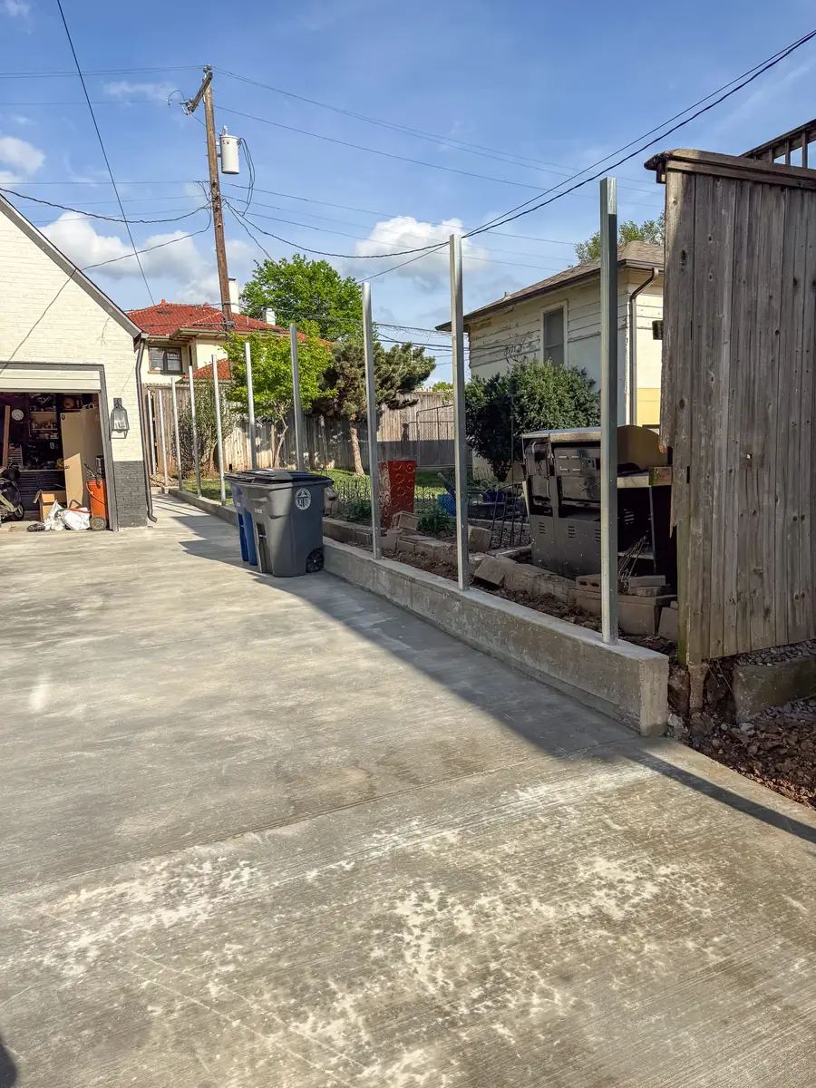 Concrete driveway running along a fence line to a garage