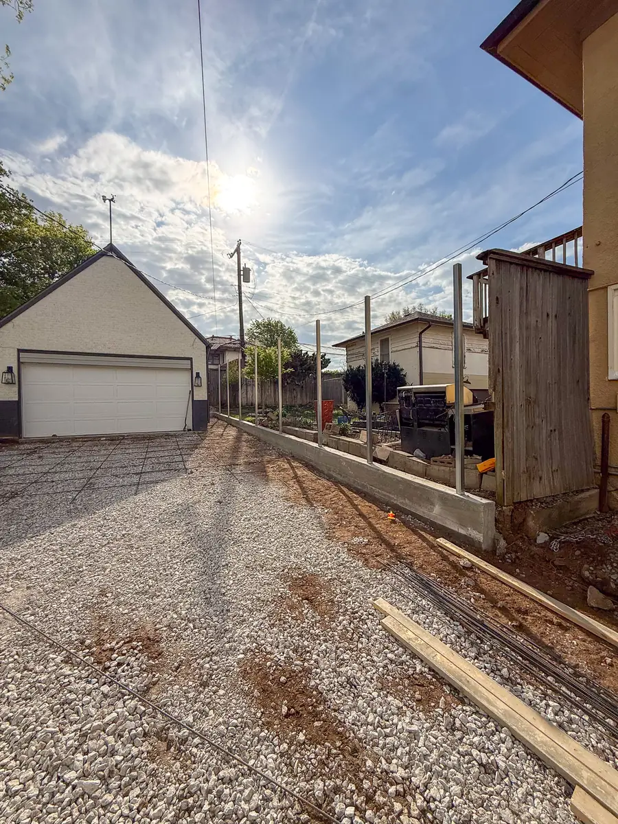 Driveway prep with gravel base and forms leading to a garage