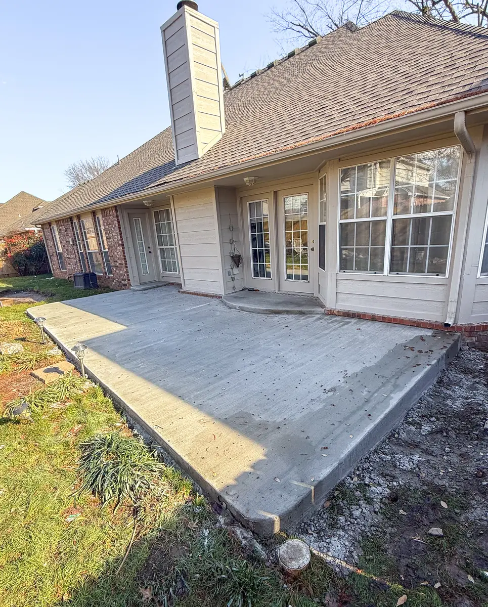 Concrete patio extension along the back of a home
