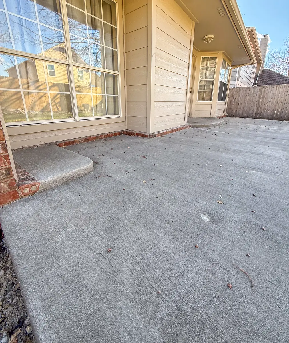 Broom-finish concrete patio extension beside a sliding door