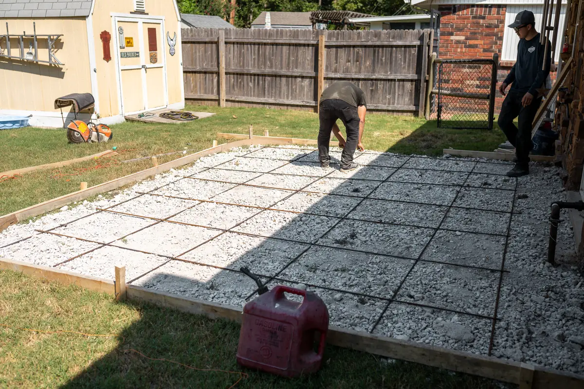 Crew tying rebar for a backyard patio pour