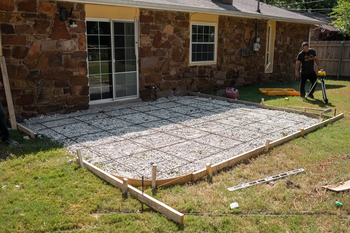 Rebar grid and forms set for a patio beside a brick home