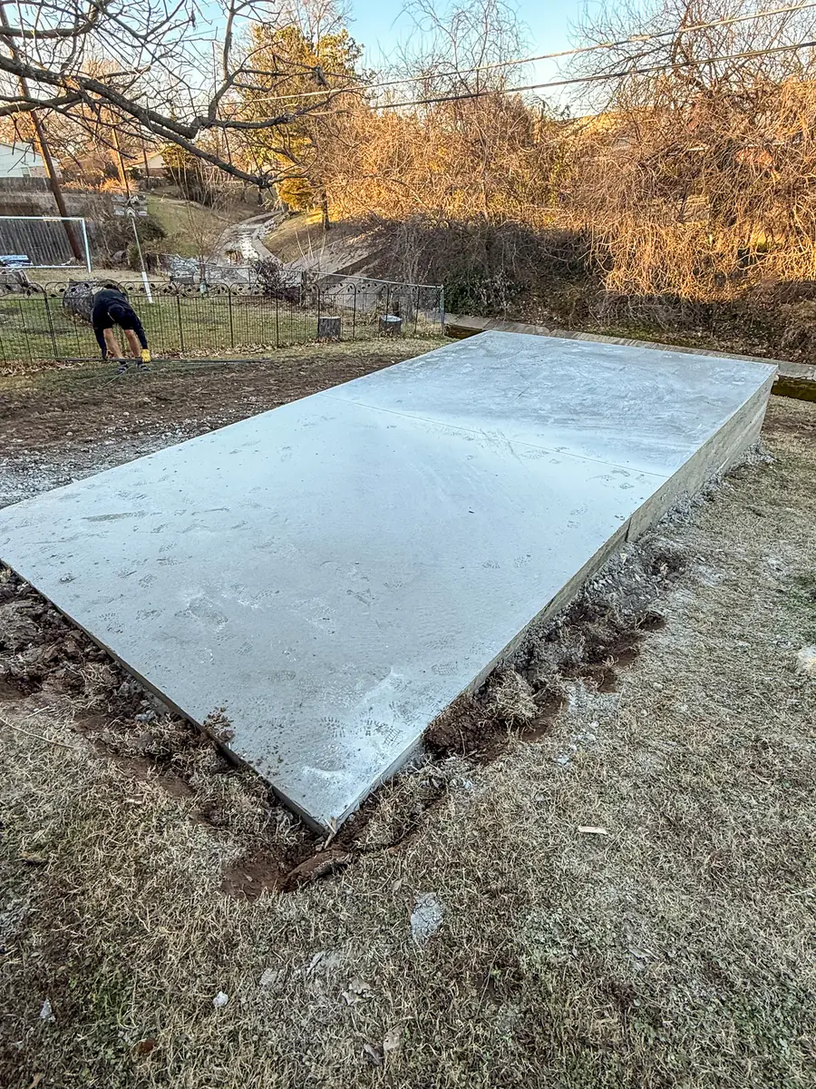 Freshly poured concrete slab pad in a backyard