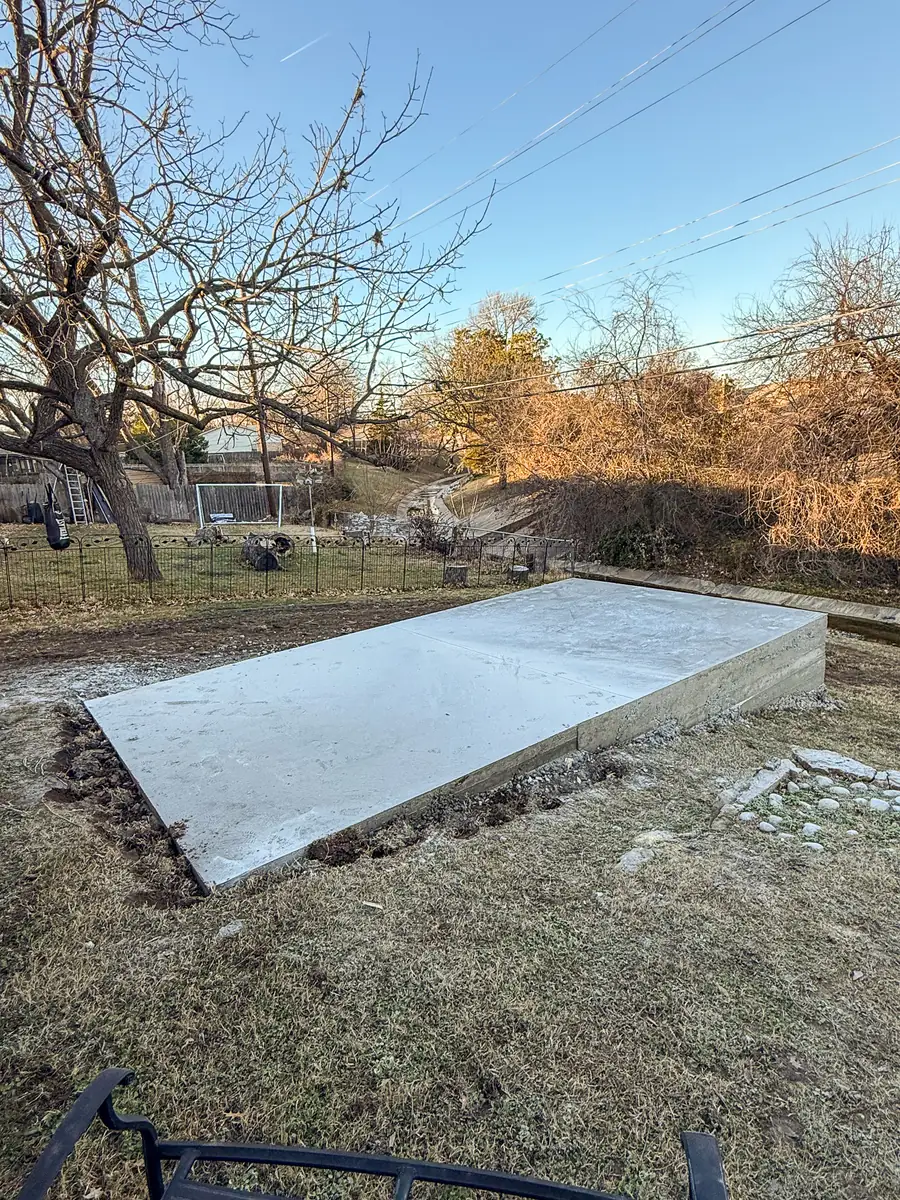 New concrete slab pad in a wooded backyard