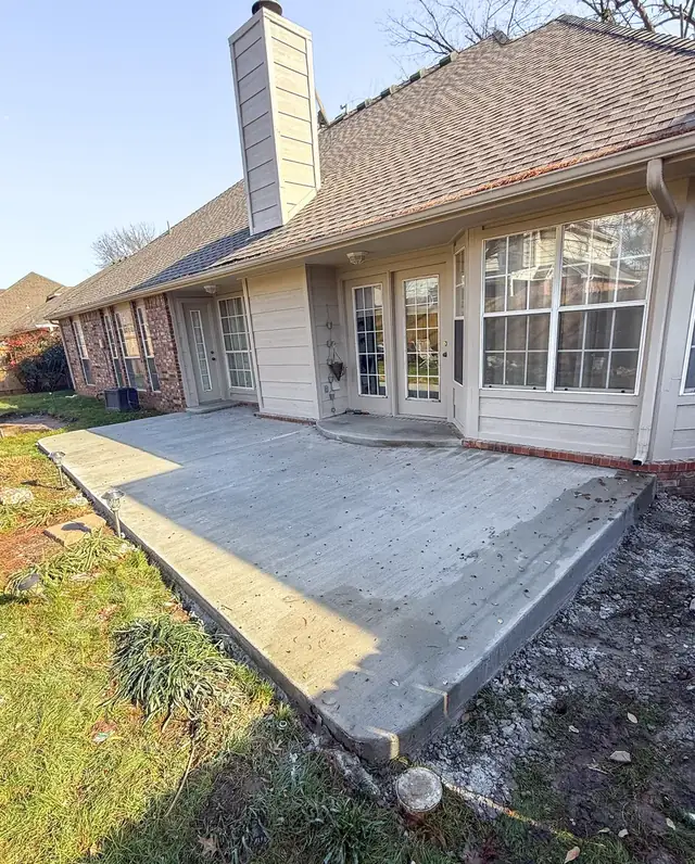 Concrete patio extension along the back of a home