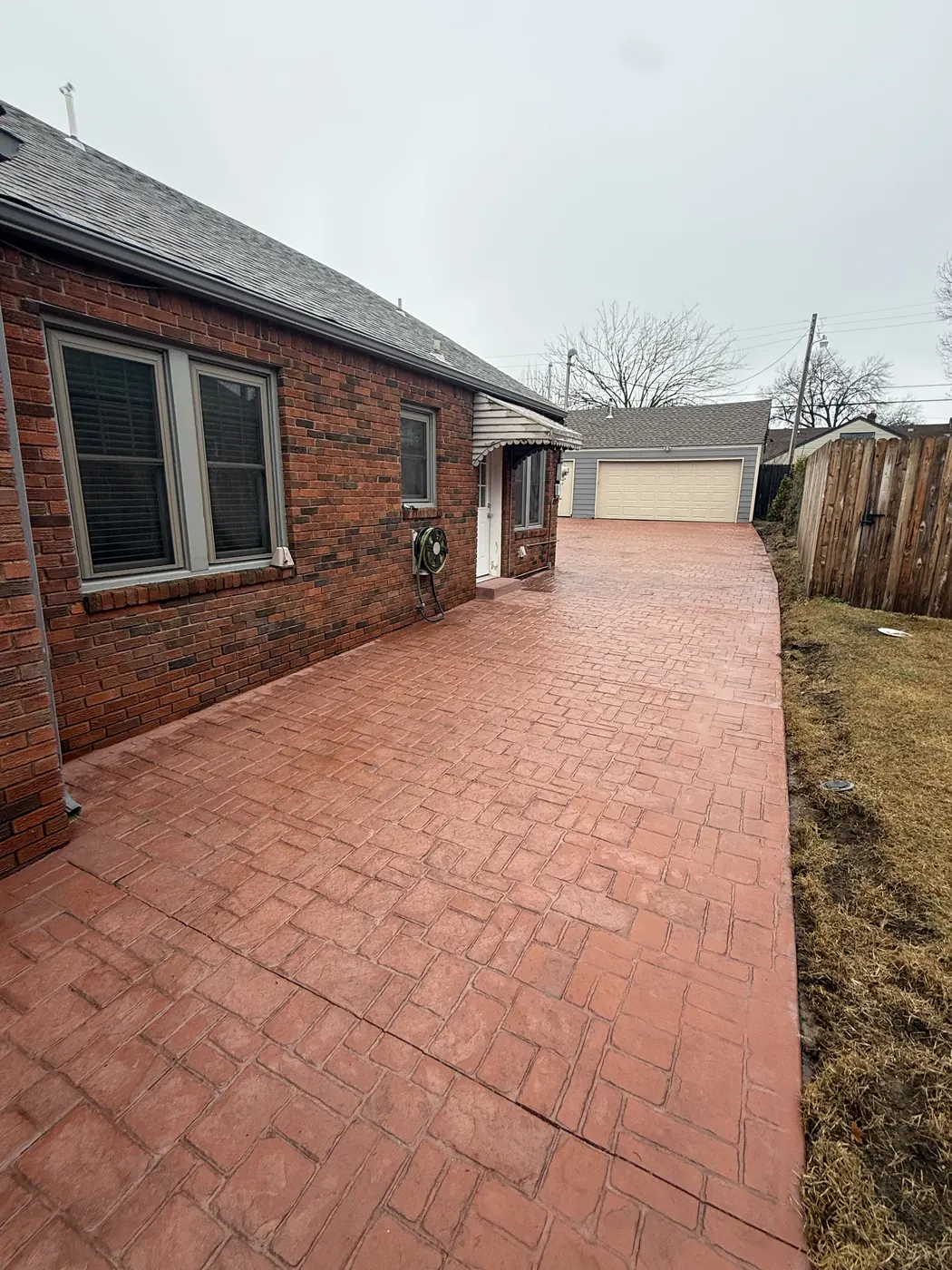 Red stamped concrete patio and drive with cobblestone pattern